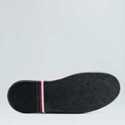 Sola preta de sapato com riscas brancas e vermelhas no calcanhar