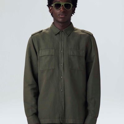 Homem com camisa verde-oliva de manga comprida e óculos de sol verdes