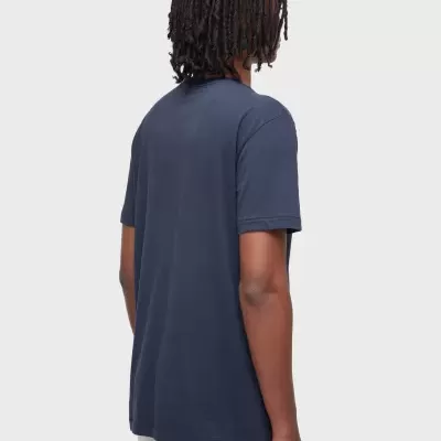 Homem de costas com t-shirt azul escuro e calças brancas