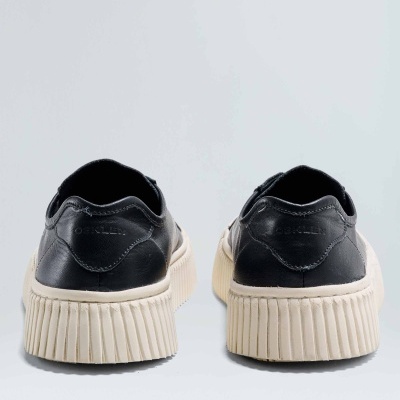 Ténis pretos com sola alta creme vistos de trás