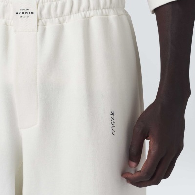 Calças desportivas brancas com cós elástico e texto HYBRID