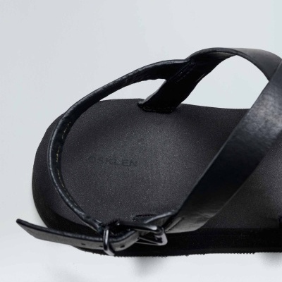 Sandália preta em pele com tiras cruzadas e fivela ajustável.