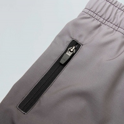 Calças desportivas cinzentas com bolso e fecho de correr preto