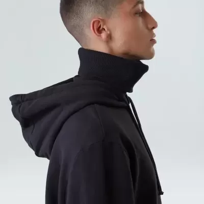 Perfil de pessoa com casaco preto de capuz e gola alta