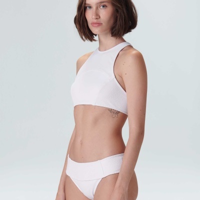 Mulher com biquíni branco de top desportivo e braguilha larga