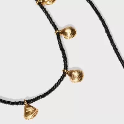 Colar com contas pretas e pendentes dourados em forma de concha
