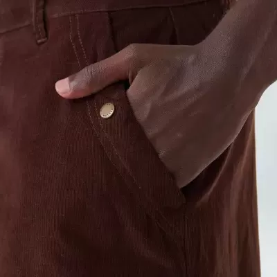 Calça de tecido corduroy castanho com bolso lateral e botão metálico