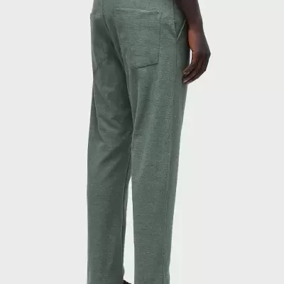 Calças verdes macias com bolsos traseiros, usadas com camisa preta e sapatos castanhos.