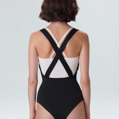 Fato de banho feminino preto e branco visto de costas com alças cruzadas.