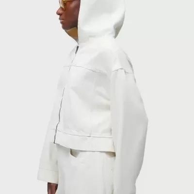 Casaco branco com capuz e costuras visíveis, visto de perfil