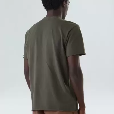 Homem de costas com t-shirt verde-oliva e calças castanhas.