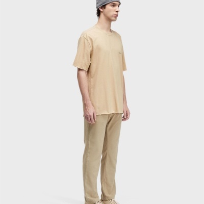 Homem com camisola, calças, sapatilhas e gorro em tons bege e cinza