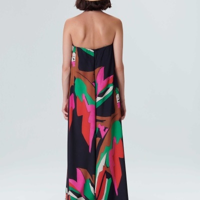 Vestido longo colorido sem alças visto de costas com chapéu de palha