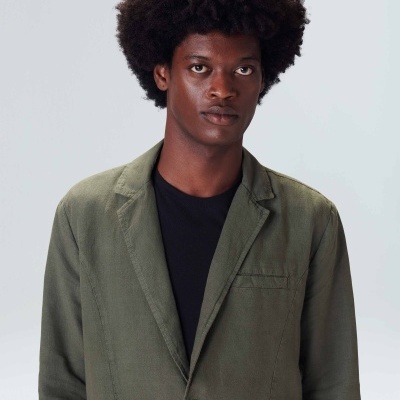 Blazer verde de algodão com botão e t-shirt preta em fundo branco