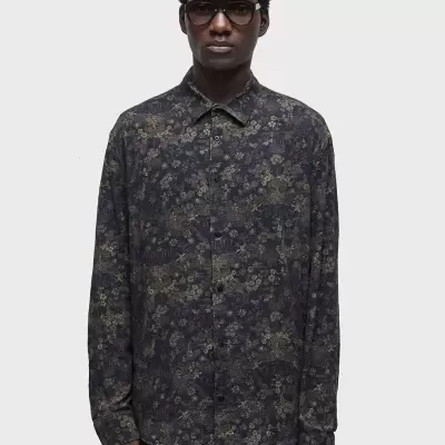 Camisa de botão floral escura com colarinho clássico usada por modelo.