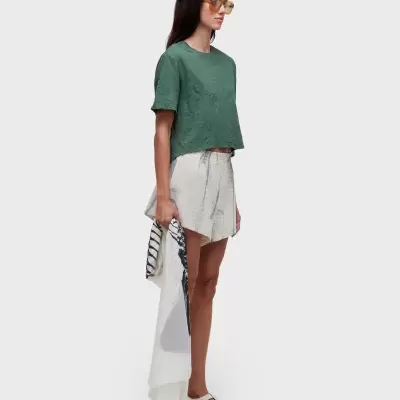 Modelo com roupa casual feminina verde e calções claros