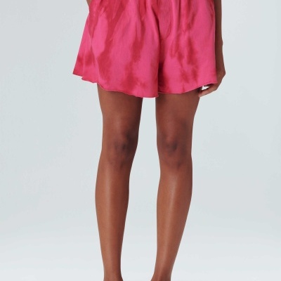 Shorts rosa sedosos com cintura elástica e bolsos, usados com calçado branco