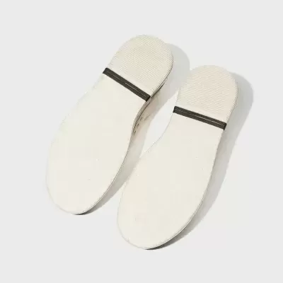 Solas de calçado brancas com faixa preta, textura lisa e riscada