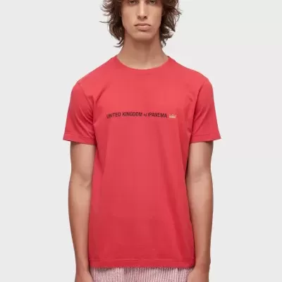T-shirt vermelha com texto e calções de banho brancos às riscas vermelhas