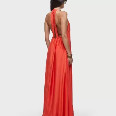 Vestido longo laranja com costas abertas e alças largas em fundo cinza claro