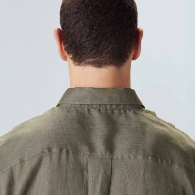 Parte de trás da cabeça e ombros de pessoa com camisa verde-oliva