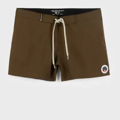 Calções de banho castanhos com cordão branco e emblema circular na perna direita