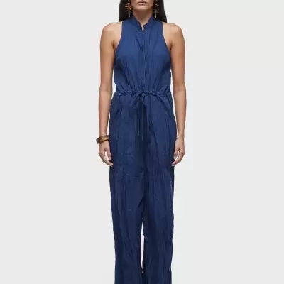 mulher com macacão azul escuro sem mangas e óculos escuros