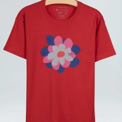 T-shirt vermelha com estampa de flor em cores variadas pendurada em cabide de madeira.