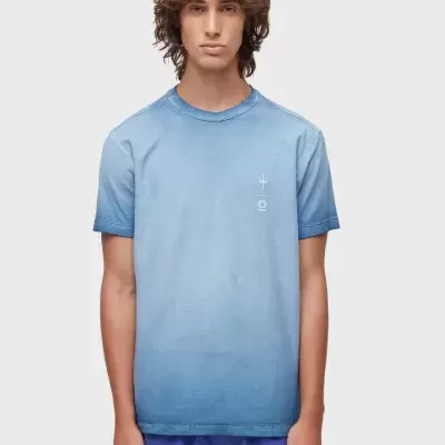 T-shirt azul degradé com símbolos brancos no peito usada por um homem com calções azuis