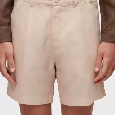 Calções bege com botão e cinto usados com camisa castanha