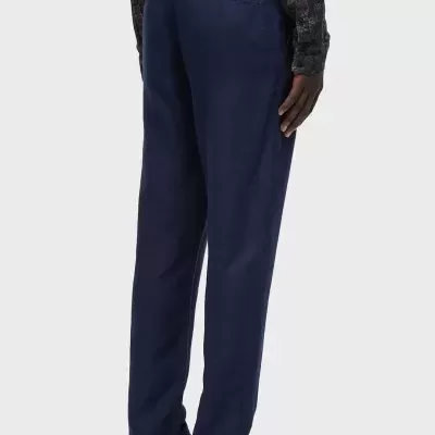 Calças azuis escuras masculinas com bolso traseiro, sandálias castanhas e camisa estampada