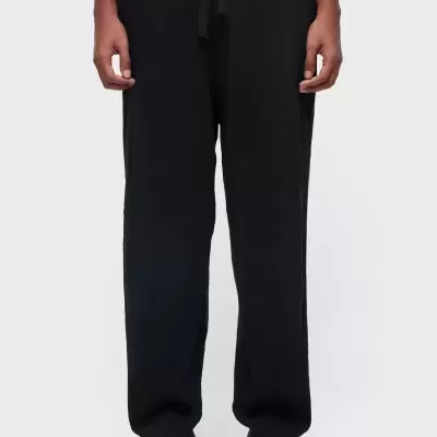 Calças pretas de tecido com textura e cordão na cintura