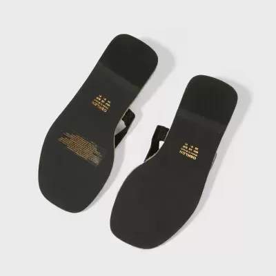 Solas pretas de sandálias OSKLEN com texto dourado, vista de baixo