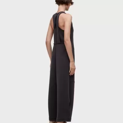 Macacão preto largo com ténis bege visto de costas