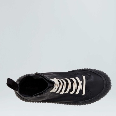 Ténis preto em pele com atacadores brancos visto de cima.