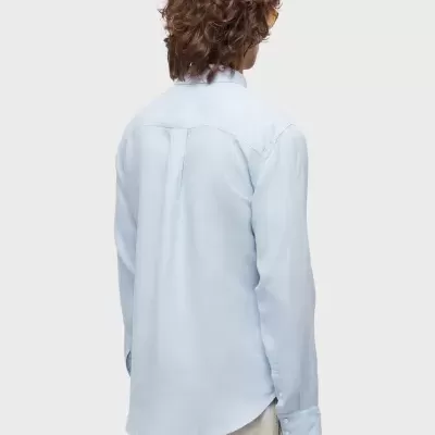 Homem de costas usando camisa azul clara e calças bege