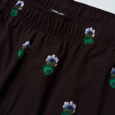 Calças ou pijama pretas com flores pequenas e etiqueta OSKLEN na cintura