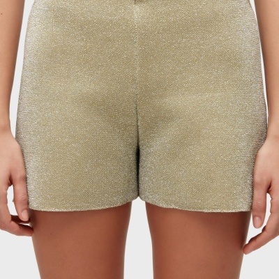 Calções curtos dourados brilhantes com textura cintilante.