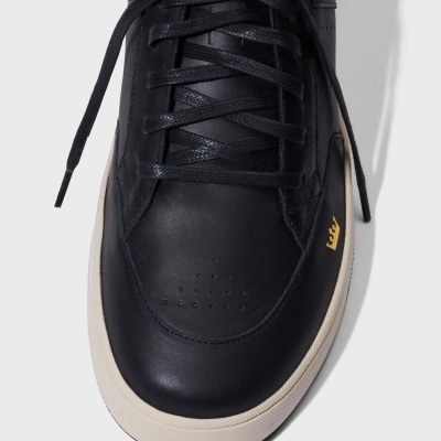 Ténis preto de pele com atacadores pretos e sola branca