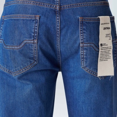 Parte traseira de jeans azuis com etiqueta branca no bolso direito