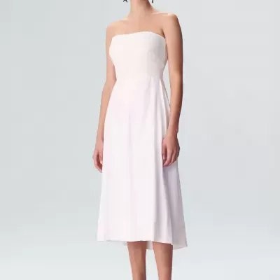 Vestido branco midi tomara que caia em modelo com sandálias azuis.