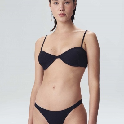 Mulher jovem a usar bikini preto simples com alças finas