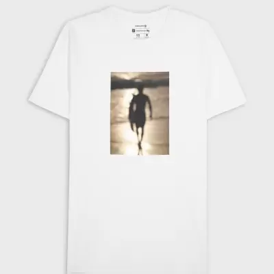 T-shirt branca com imagem desfocada de pessoa na praia