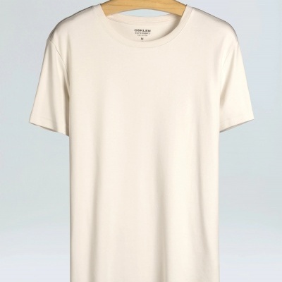 T-shirt branca básica pendurada num cabide de madeira OSKLEN