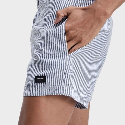Calções de banho riscado azul e branco com etiqueta OSKLEN e bolso lateral com mão.