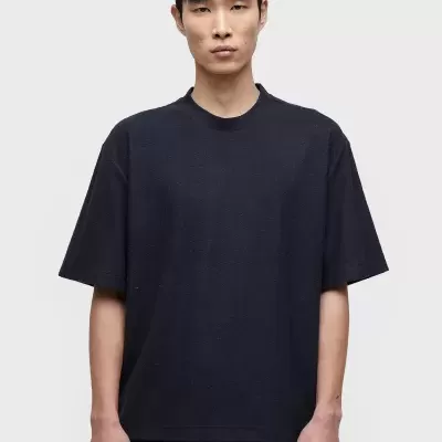 Camiseta preta de manga curta usada por modelo masculino.