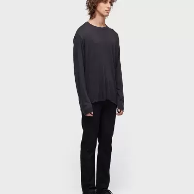 Homem com t-shirt e calças pretas, sapatilhas pretas, fundo branco