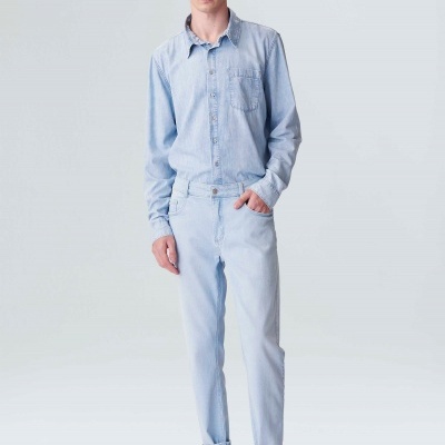 Homem com camisa e calças de ganga azul claro e sapatos brancos