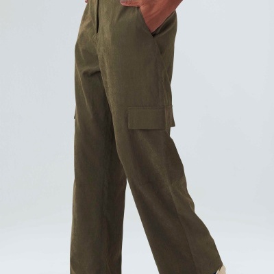 Calças cargo largas verdes com bolso de aba, t-shirt branca e sapatos brancos com detalhes azuis