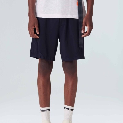 Homem a usar shorts pretos e uma camiseta branca com meias brancas e sapatos claros